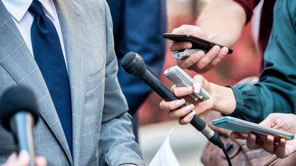 Media Interview - journalists with microphones interviewing formal dressed politician or businessman.