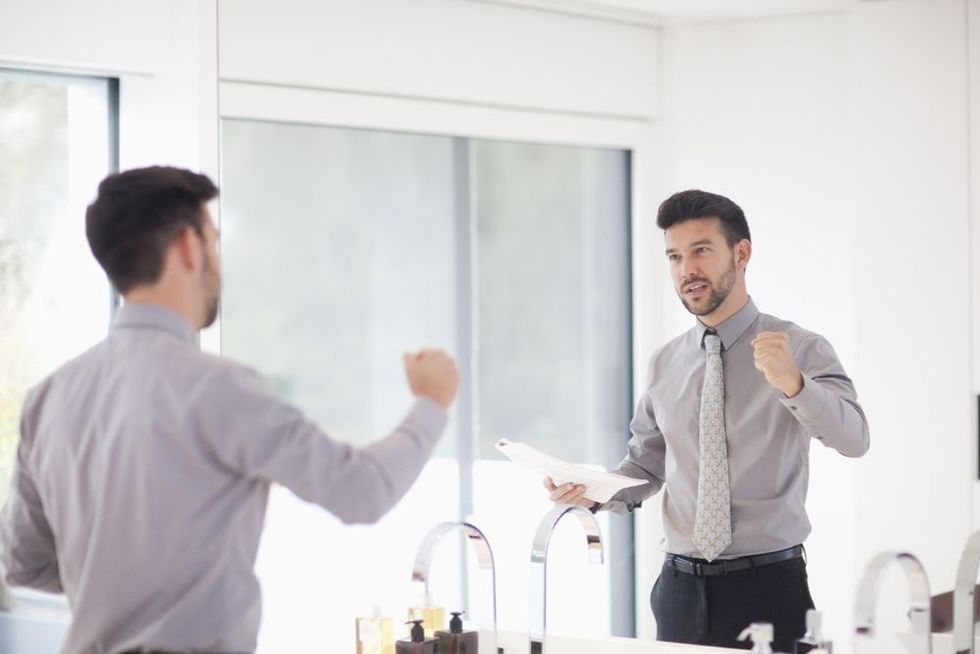 Mid adult businessman practicing presentation in mirror