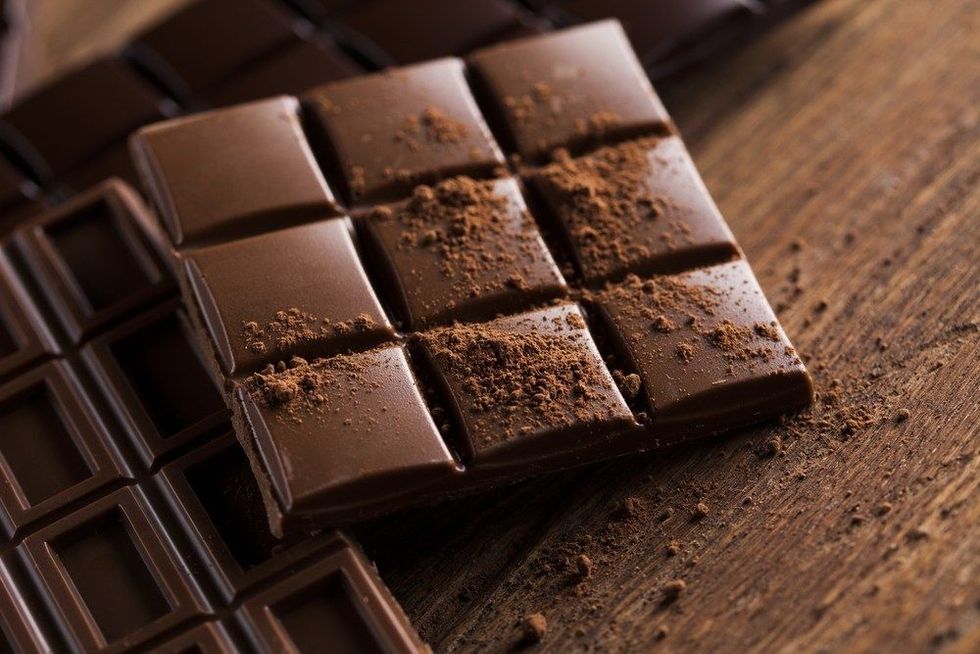 Milk and dark chocolate on a wooden table.