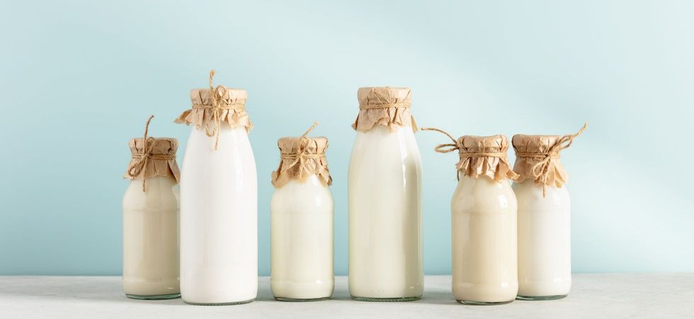 Milk in bottles on blue background.