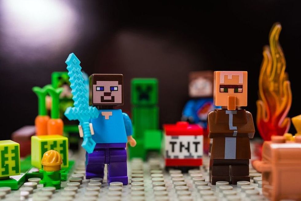 Minecraft game characters with one holding a sword.