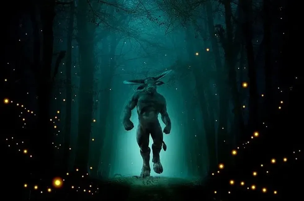 Minotaur a mythical creature - half man half bull walking in a dark forest