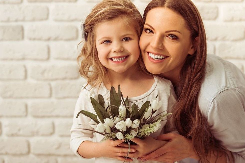 Mother and daughter holding flowers in hand