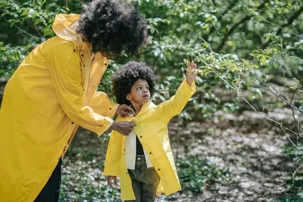 Mother and daughter in yellow jackets in forest