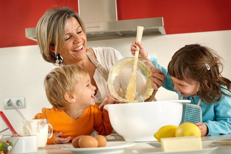 Mother and kids laughing together while cooking