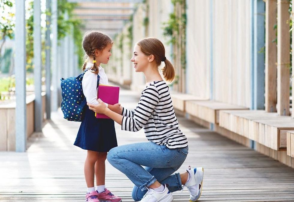 Mother dropping her daughter for school day.