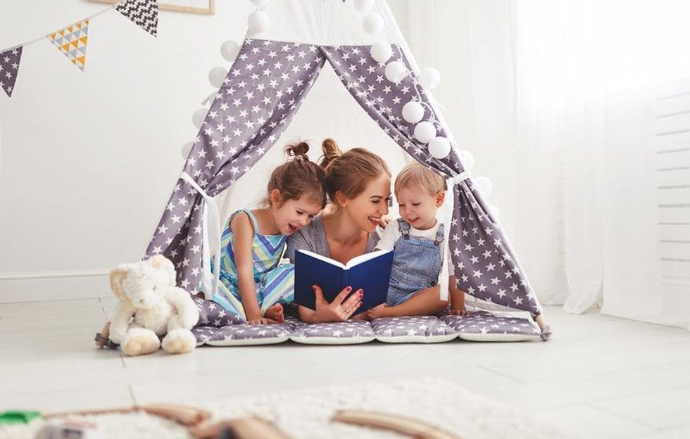 Mother Reading A Book To Her Little children.