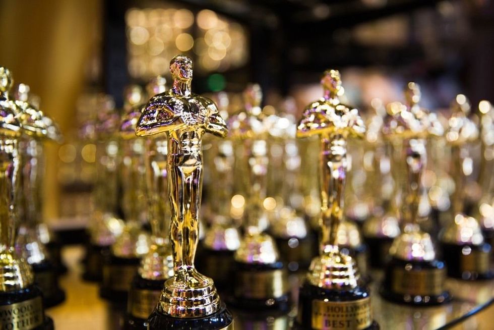 Multiple Oscar awards in focus, with rows of blurred awards in the background, symbolizing Academy Award Facts.