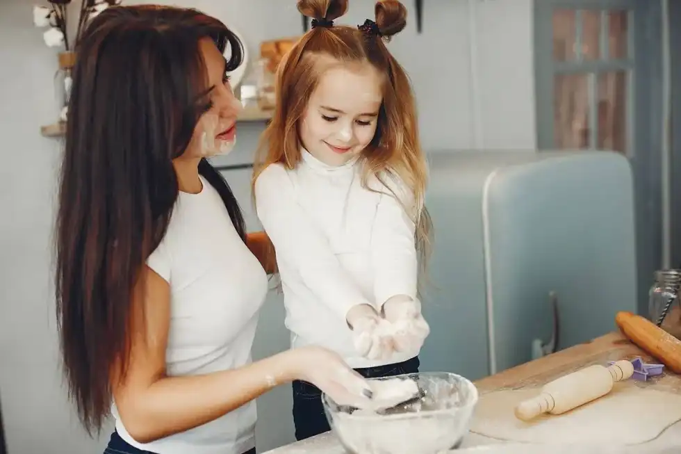 Mum and daughter in the kitchen baking a car cake together.