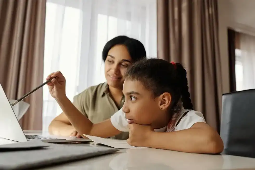 Mum and daughter sat at desk with their laptop learning about the Spanish Armada.
