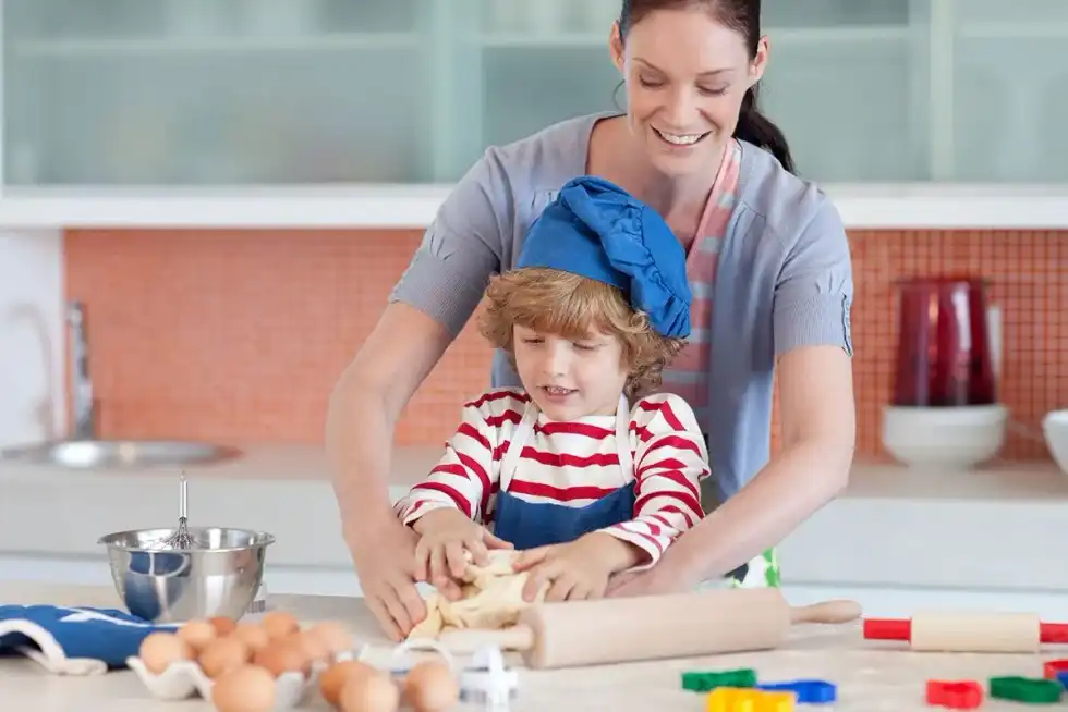 Mum and son in the kitchen making a Fortnite birthday cake together.