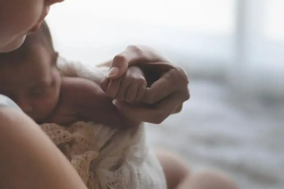 Mum cradling her newborn baby after a water birth.