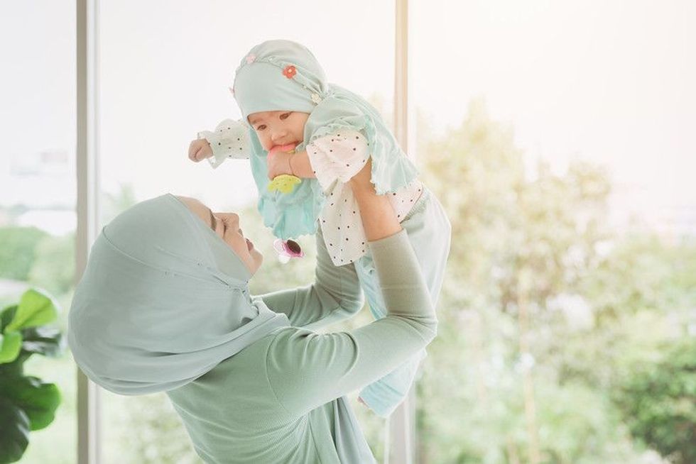 Muslim mother playing with her newborn baby