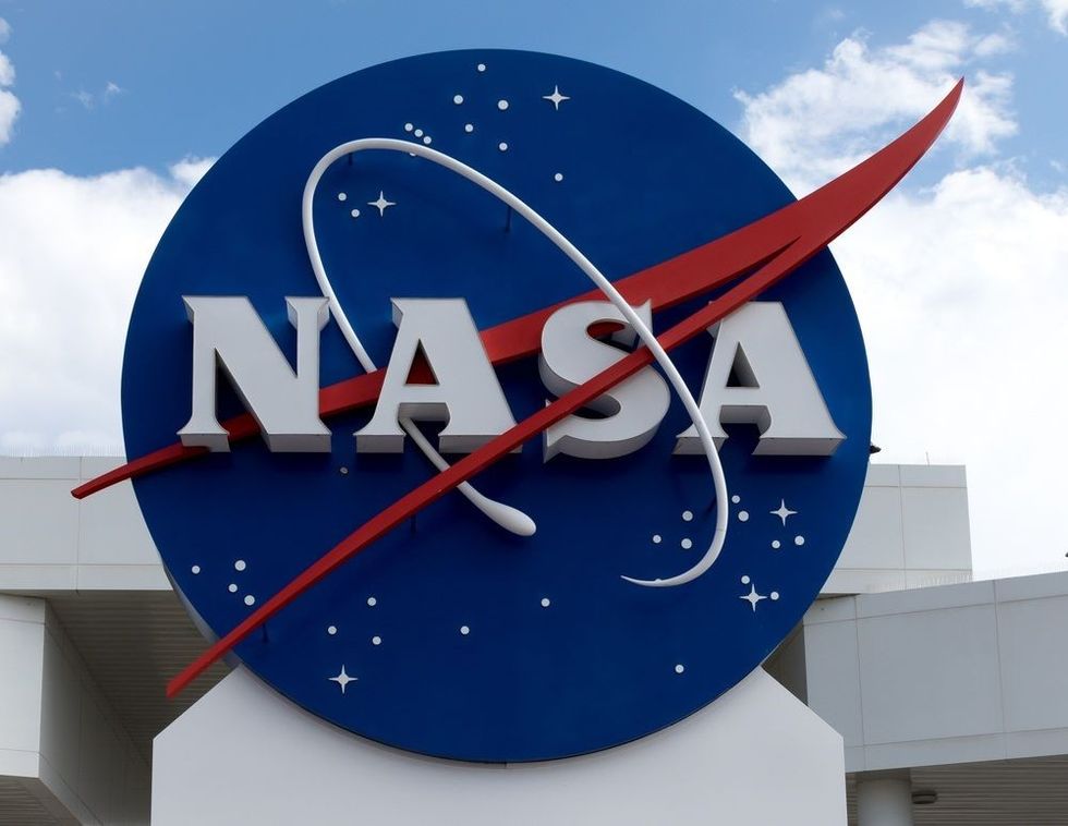 NASA sign at Cape Canaveral, Kennedy Space Center with blue cloudy sky background.