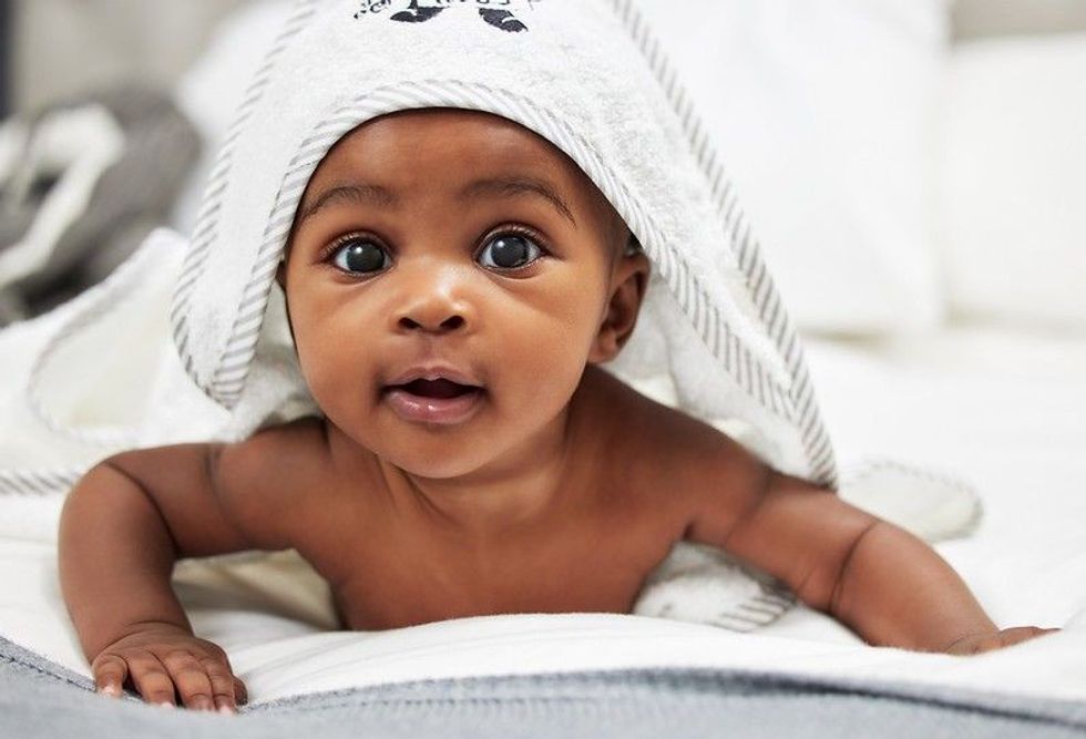 Newborn baby covered in white towel.