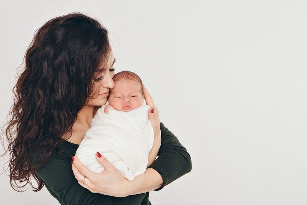 Newborn baby in the arms of the mother.
