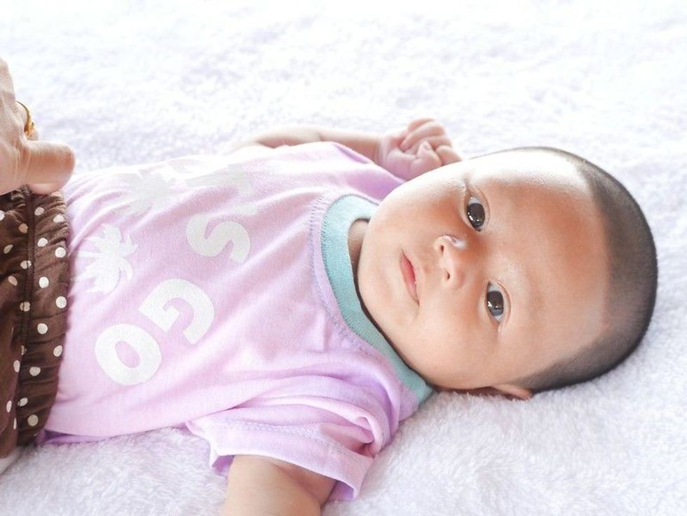 Newborn baby lying on bed