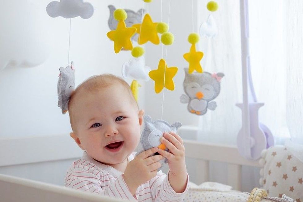 Newborn baby playing with stars and clouds mobile
