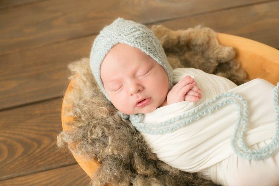 Newborn baby sleeping in a fur basket wearing knitted blue cap - Nicknames