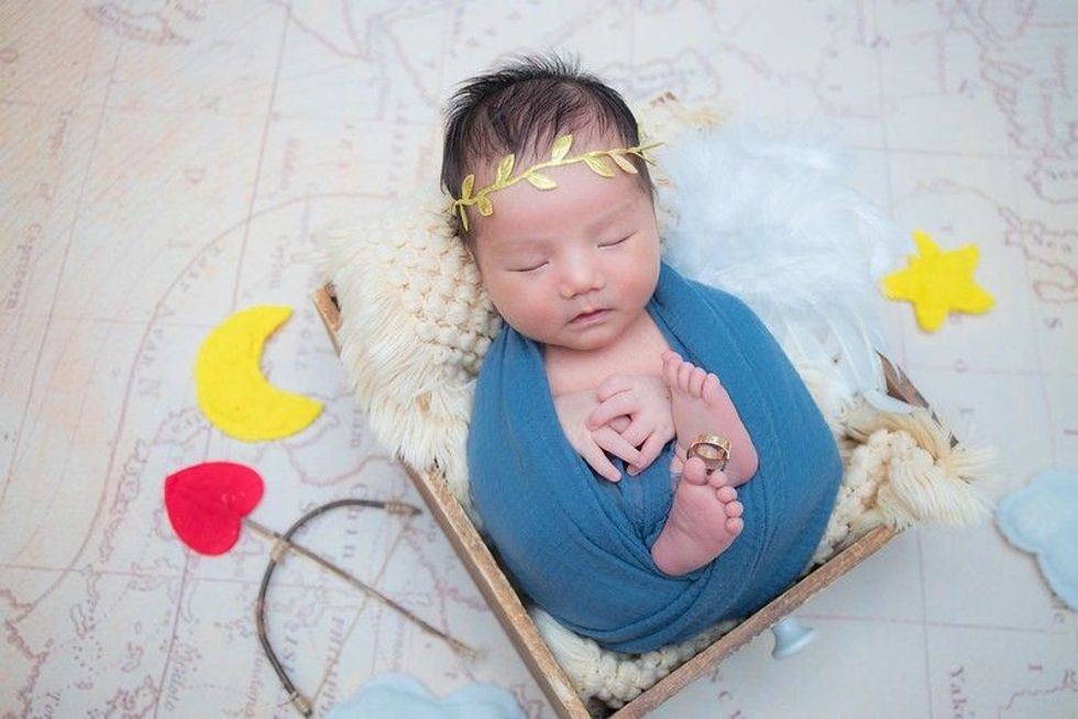 Newborn sleeping baby dressed as a cupid