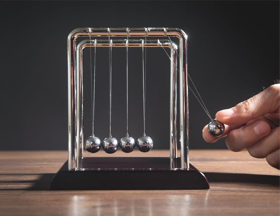 Newtons cradle balls on the wooden table