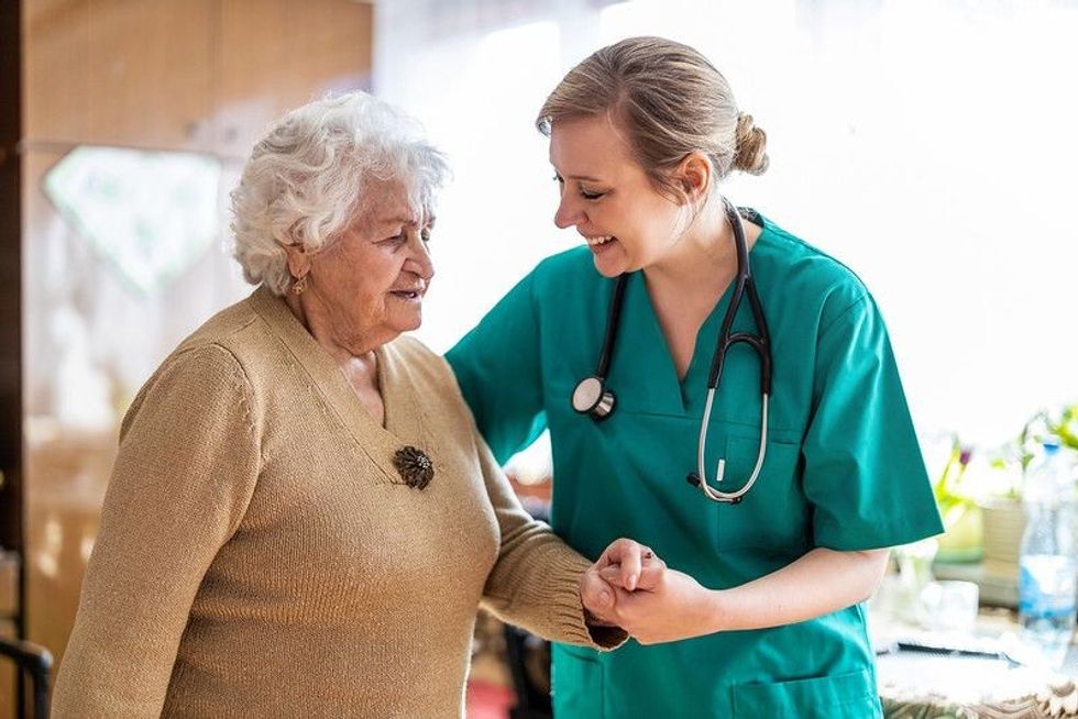 Nurse talking to a senior woman during home visit