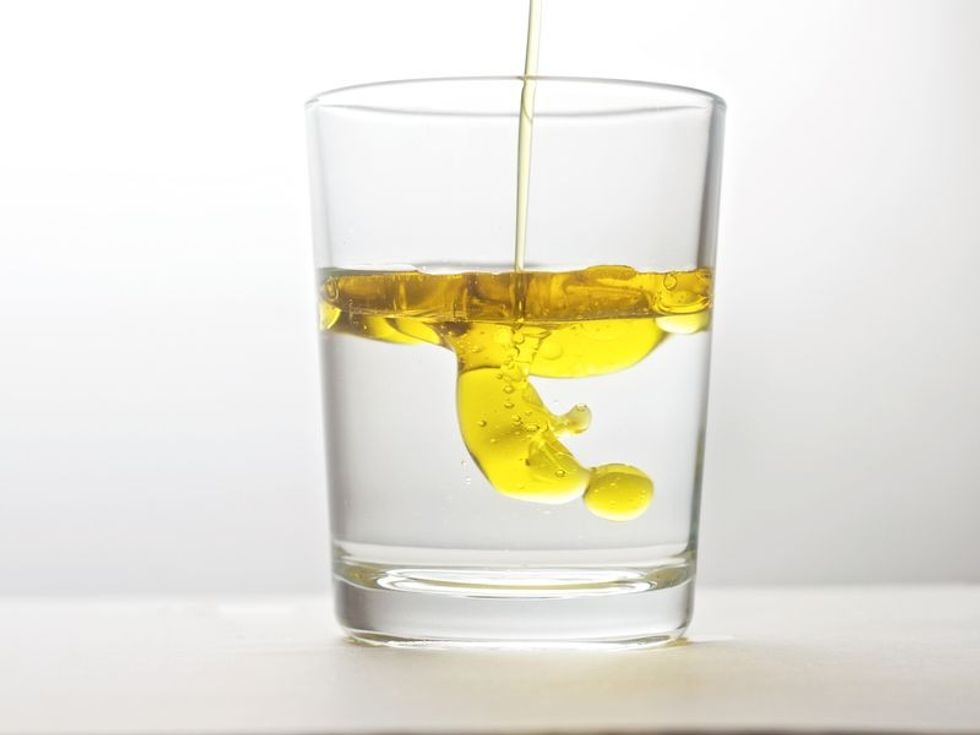 Oil floating on water in a glass.
