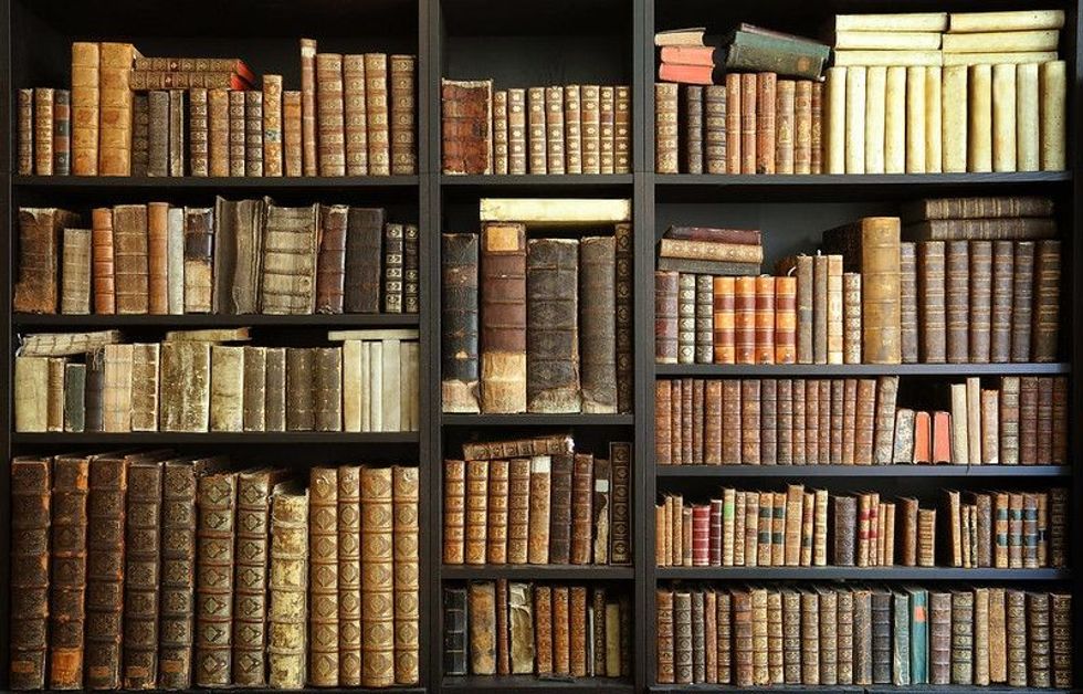 Old books on a wooden shelf.