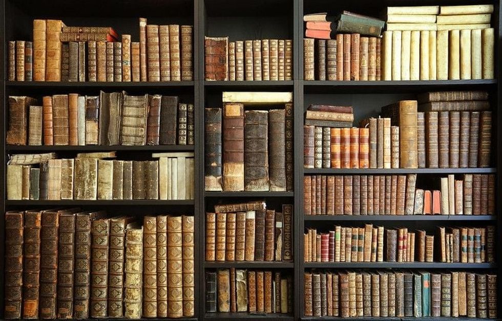 Old books on a wooden shelf.