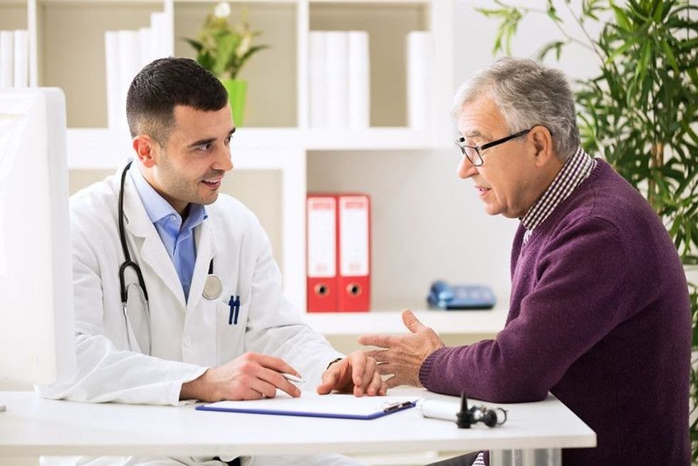 Old man consulting with a doctor.