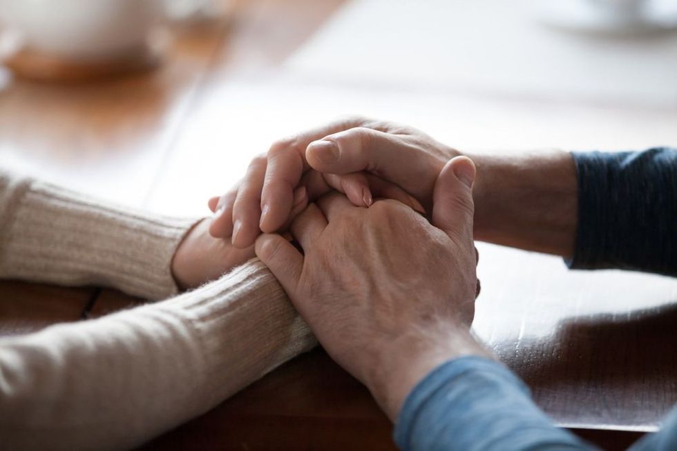 Old middle aged people holding hands close up view