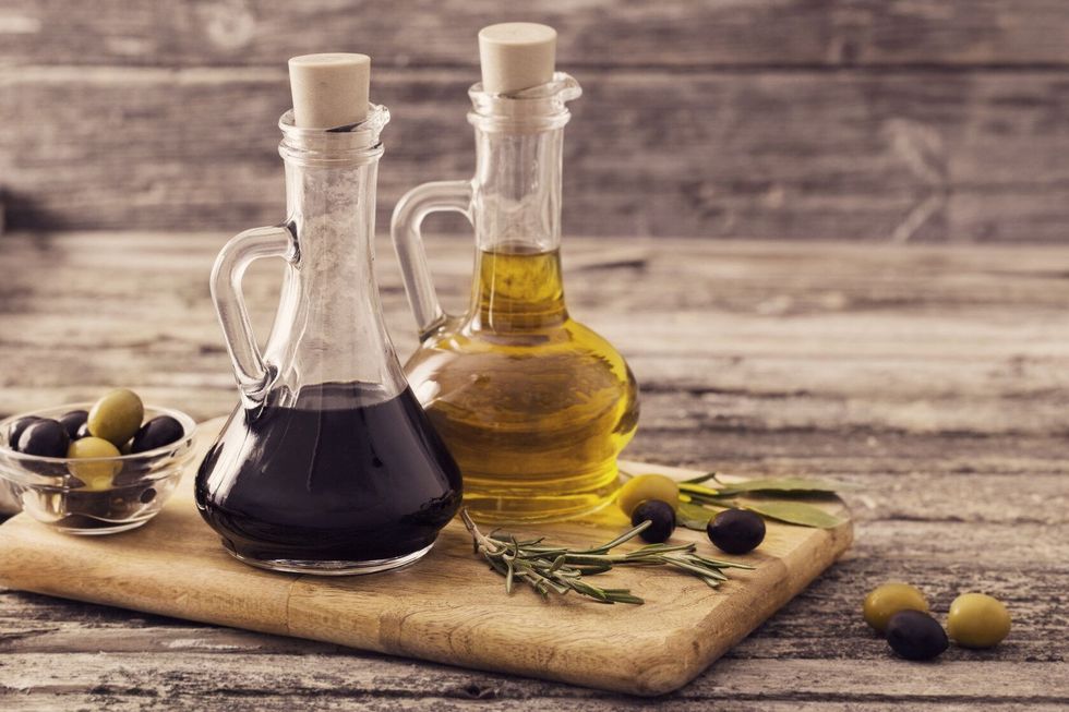 Olive oil and balsamic vinegar on a wooden background.