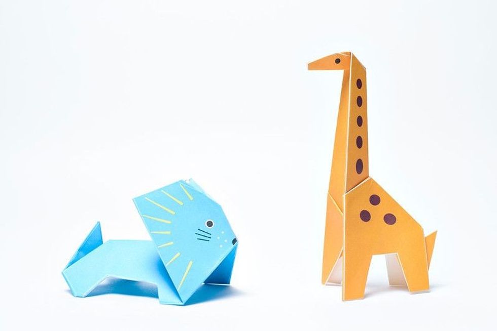 Origami giraffe and blue lion on white background.