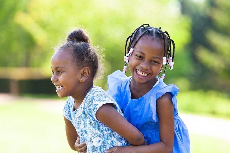 Outdoor portrait of a cute young sisters laughing - Names