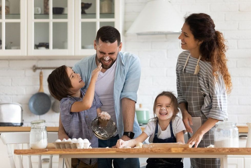 Overjoyed young family with little preschooler kids have fun cooking