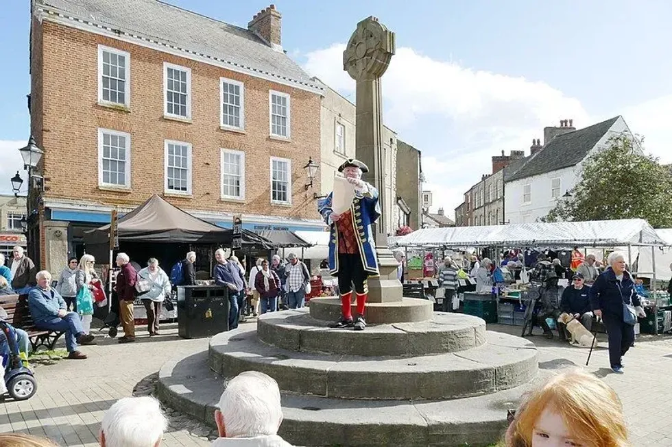 People celebrate International Town Criers Day by wearing the traditional town crier's costume.