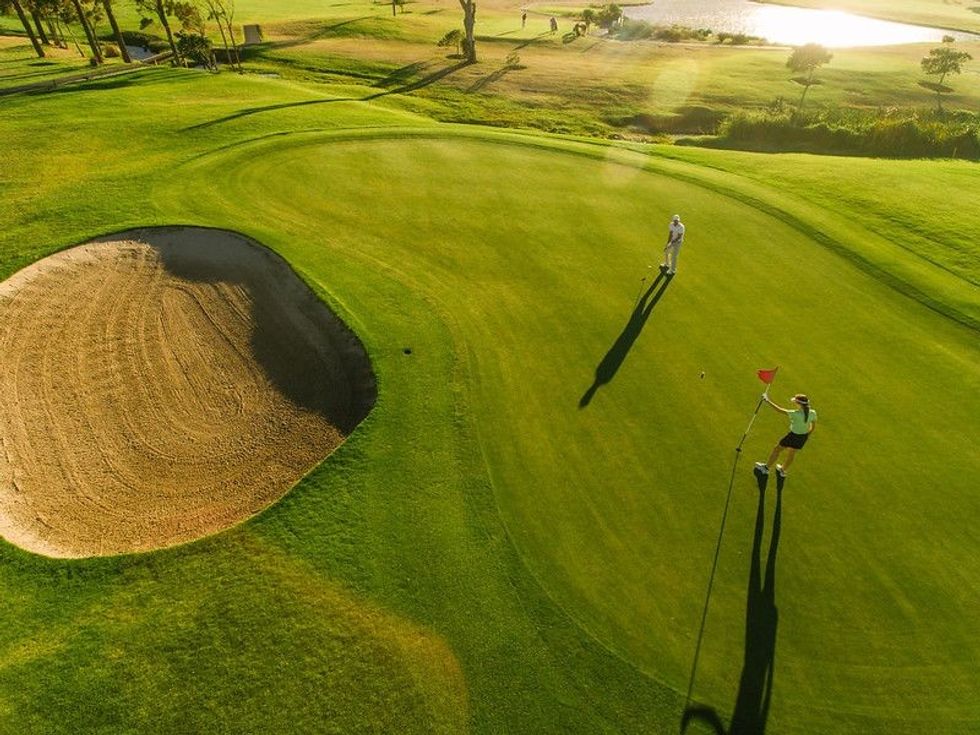 People playing golf in the feild