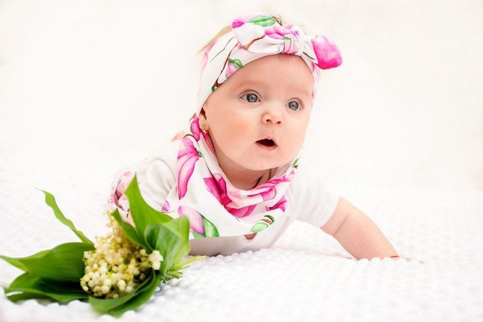 Persephone baby crawling on floor next to flowers  - Nicknames