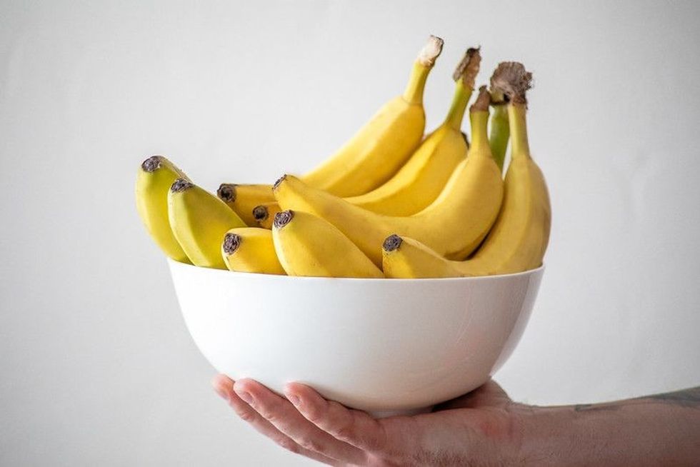 Person holding a bowl of bananas