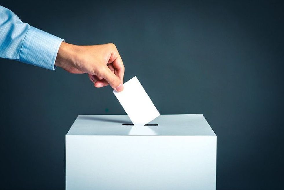 Person putting his vote card in the voting ballot.