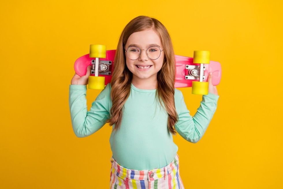 Photo of young preteen girl happy positive smile hold skateboard 