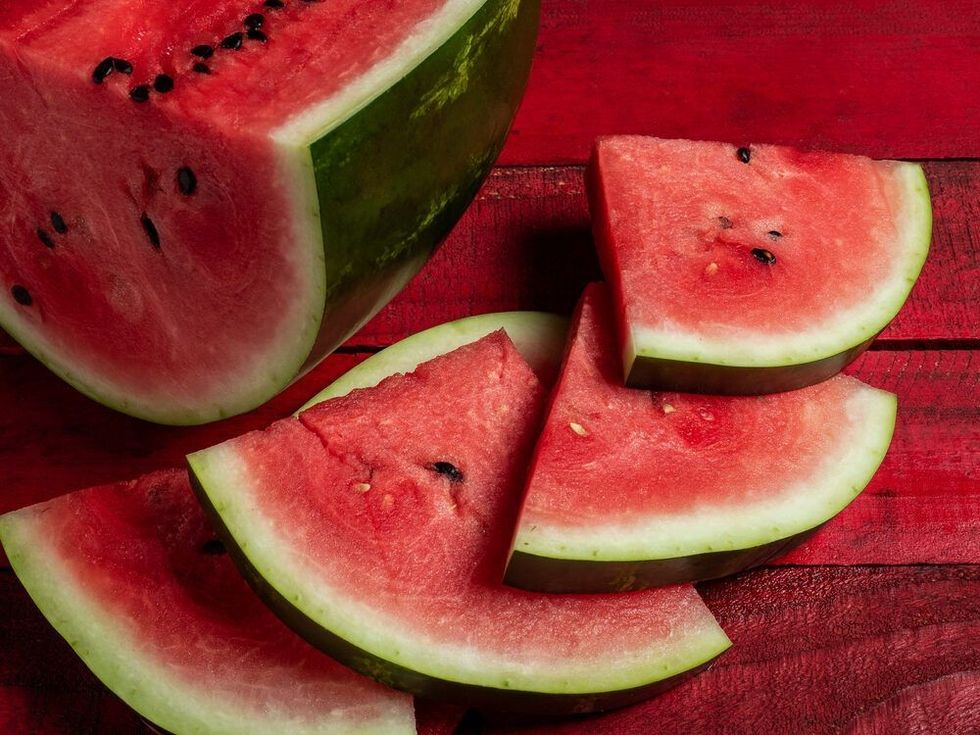 Pieces of juicy red watermelon on a wooden table.