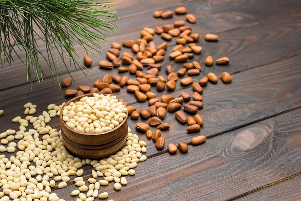 Pine nut kernels in wooden box on table. 
