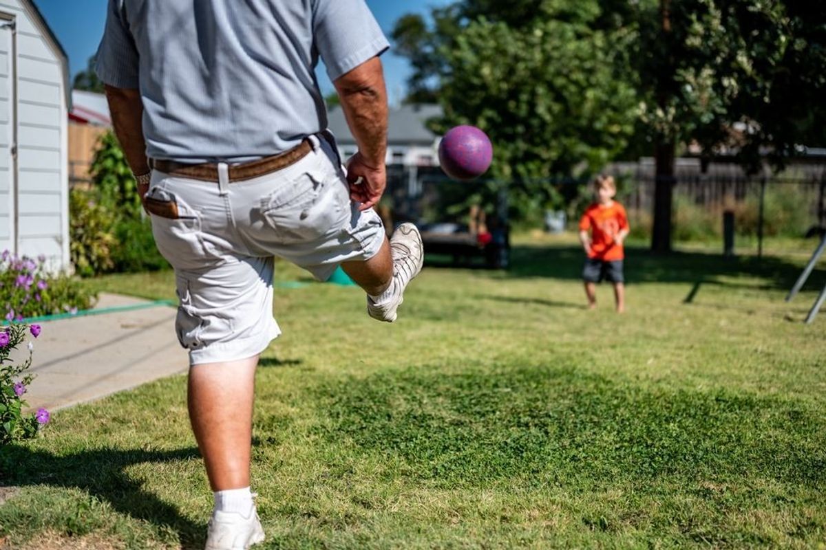 Playing kickball with grandpa in the backyard.