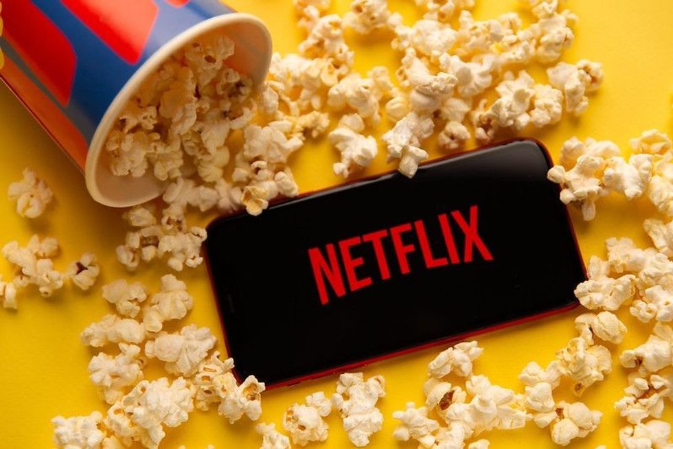 Popcorn spilling over the phone displaying Netflix