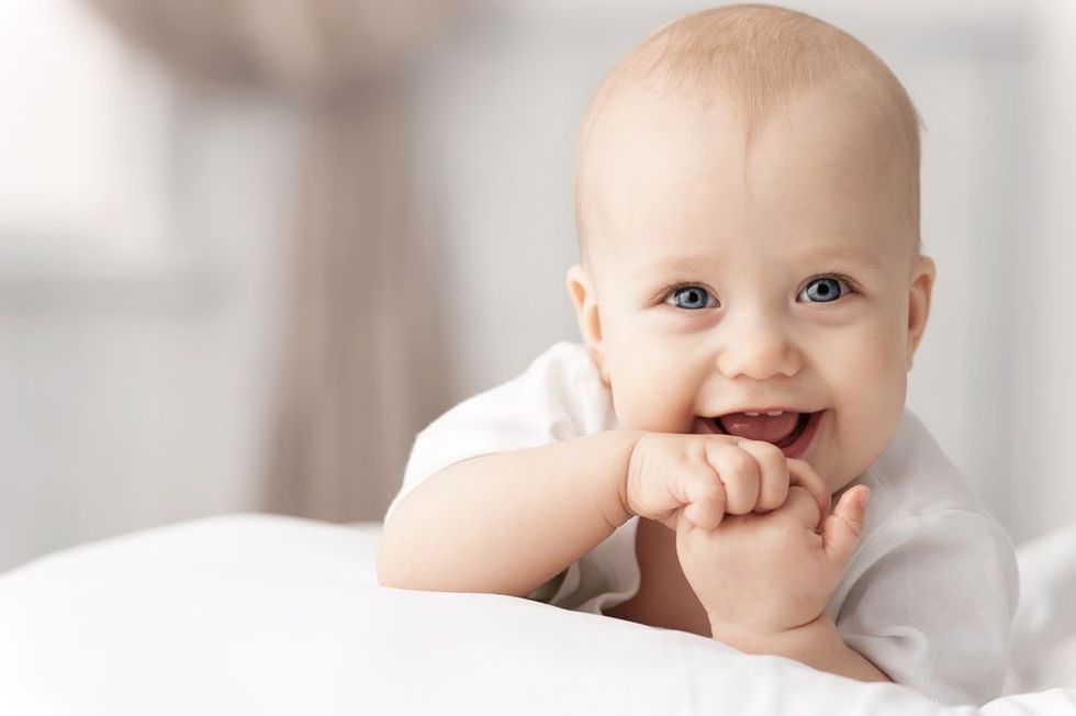 Portrait of a crawling baby on the bed in her room
