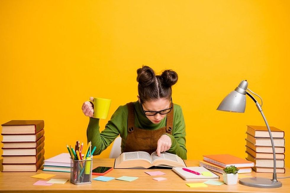 research results quotes Portrait of a girl focused knowledgeable brainy diligent woman nerd reading book finding solution drinking caffeine isolated bright vivid shine vibrant yellow color background
