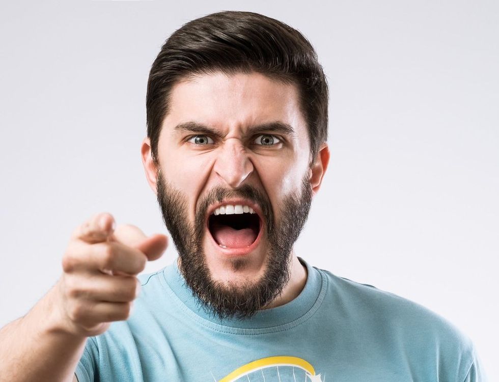 Portrait of angry bearded man screaming and pointing out by finger