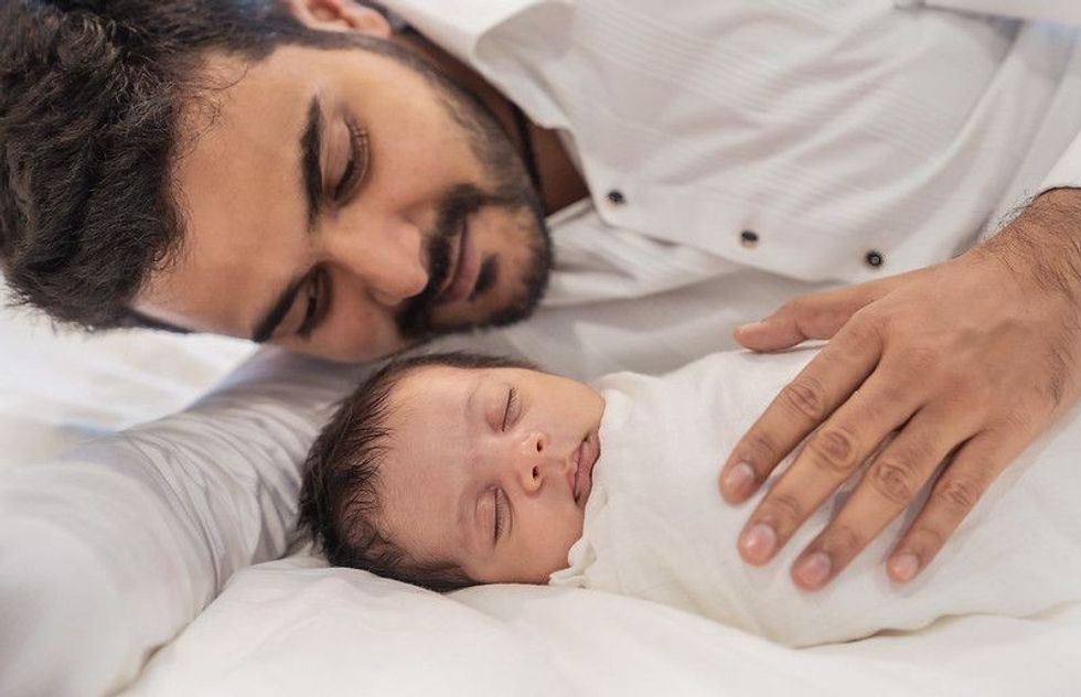 Portrait of young happy asian Indian father with his newborn baby