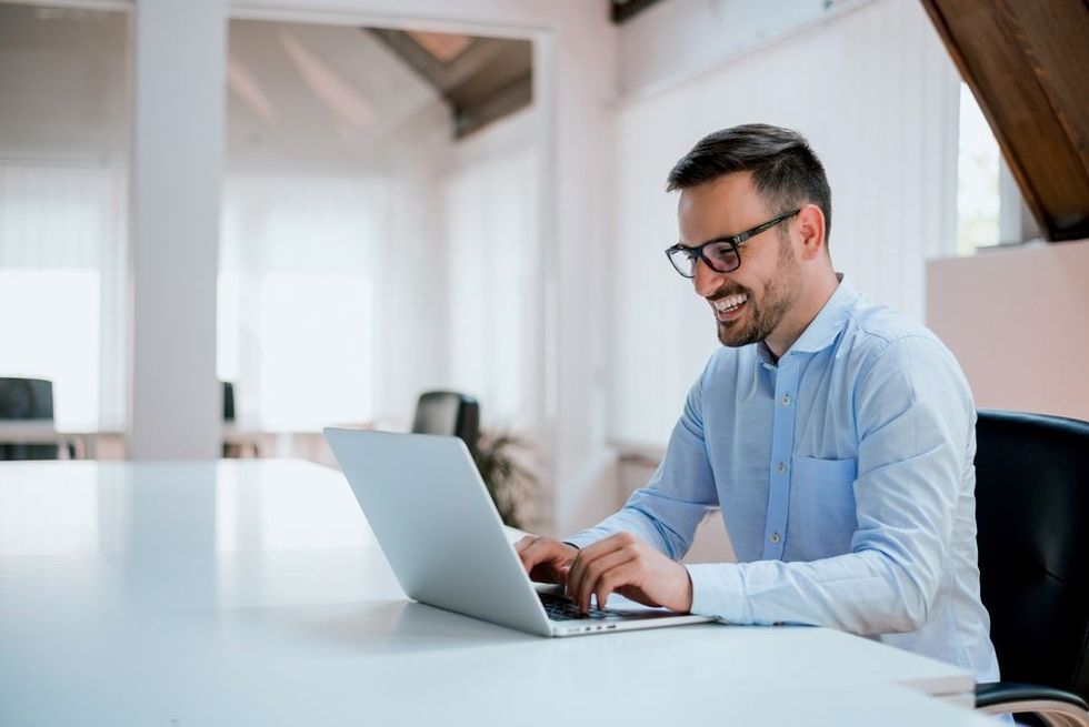 Portrait of young man sitting at his desk in the office